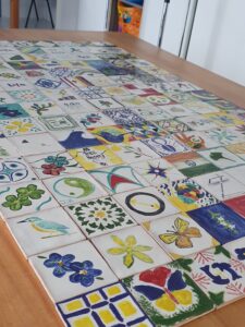 Multinational company team enjoying an authentic Portuguese tile painting mural logo experience at a Lisbon hotel