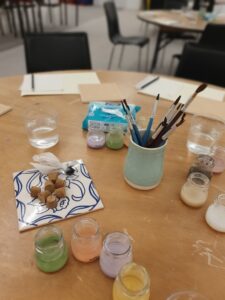Kids enjoying a hands-on ceramic tile painting experience at a hotel summer camp