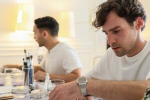 Group of professionals collaborating on hand-painted ceramic tiles at a Lisbon hotel cultural event