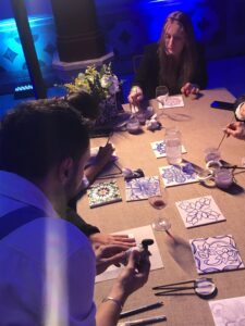 Professionals creating personalized ceramic tiles during a bespoke Lisbon corporate event
